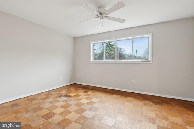 spare room featuring ceiling fan and baseboards