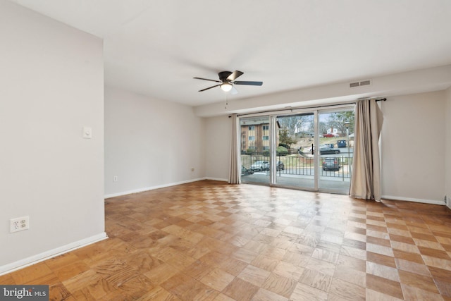 unfurnished room with baseboards, visible vents, and a ceiling fan