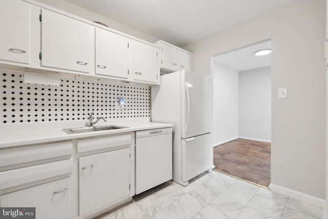 kitchen with white appliances, white cabinets, marble finish floor, light countertops, and a sink