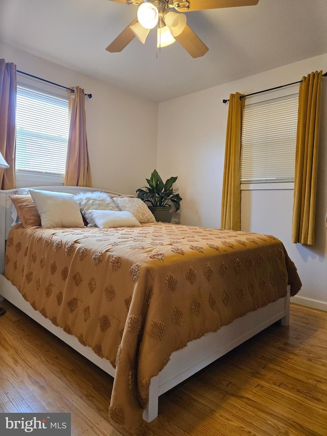 bedroom featuring ceiling fan, wood finished floors, and baseboards