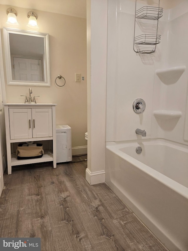 full bathroom featuring shower / bathtub combination, wood finished floors, vanity, and baseboards