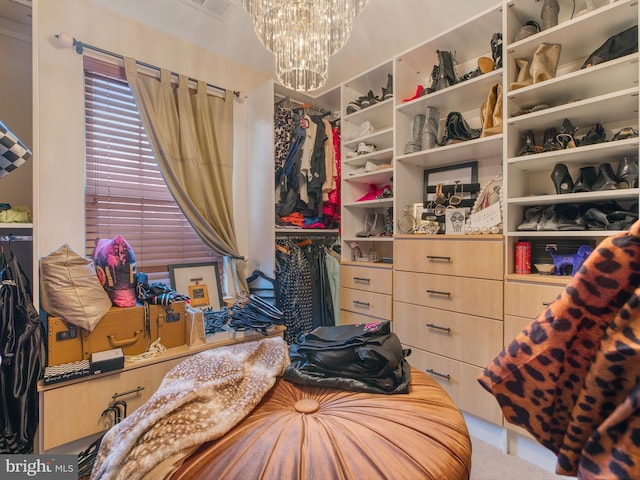 walk in closet featuring a chandelier