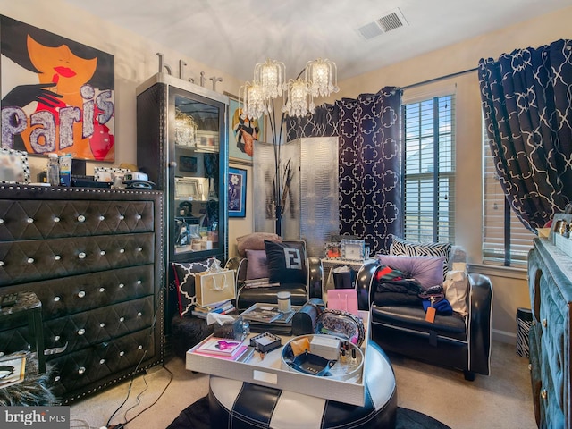 interior space with visible vents, carpet, and an inviting chandelier