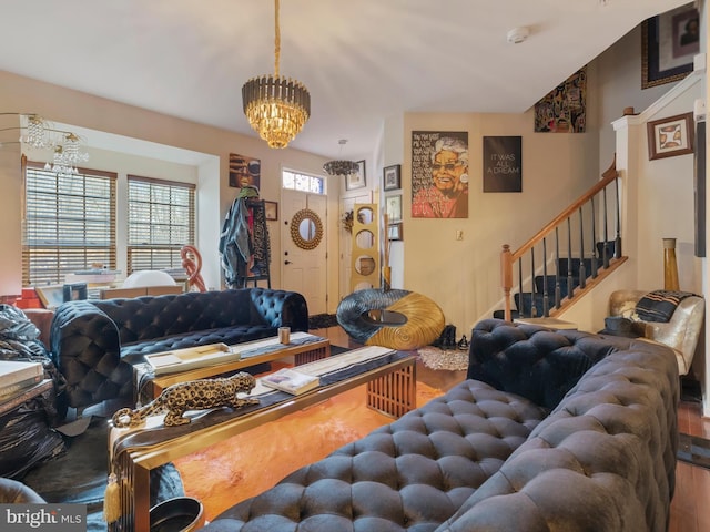 living room featuring stairway, wood finished floors, a wealth of natural light, and a chandelier