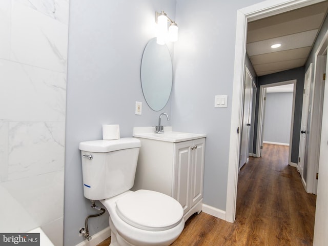 bathroom with baseboards, vanity, toilet, and wood finished floors