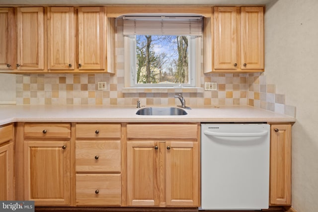 kitchen featuring light brown cabinetry, white dishwasher, a sink, and light countertops