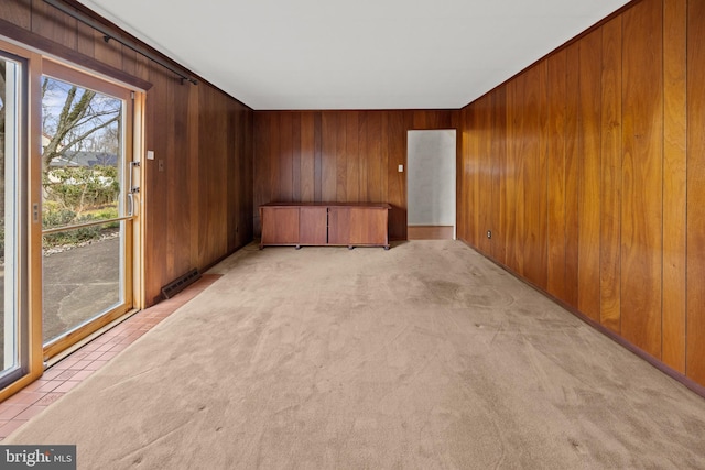 empty room with wooden walls and light colored carpet