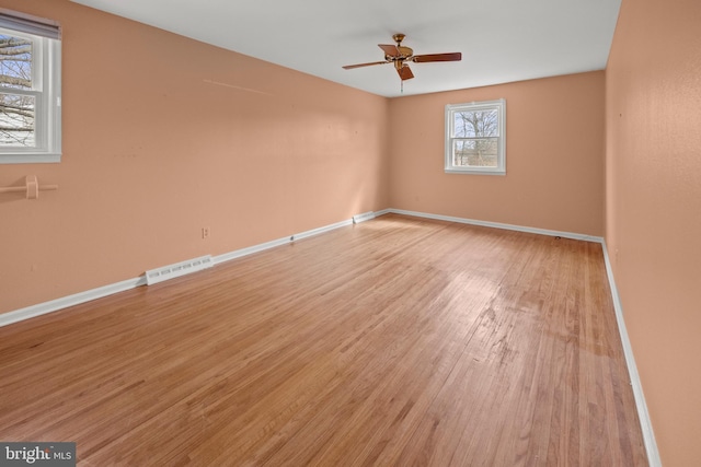 unfurnished room with light wood-style floors, visible vents, baseboards, and a ceiling fan