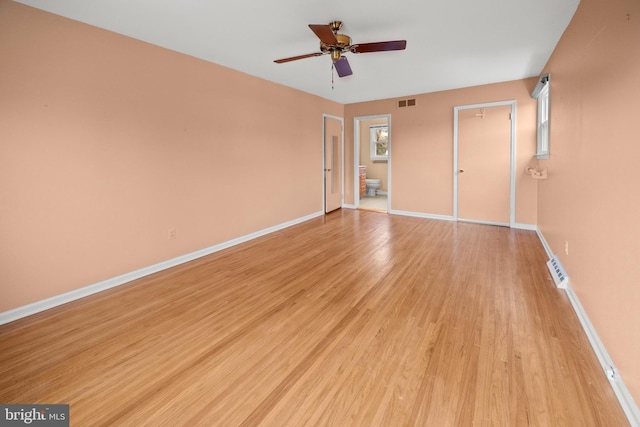 unfurnished bedroom featuring ensuite bathroom, light wood-style flooring, visible vents, and baseboards