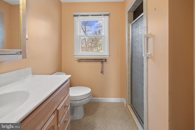 bathroom featuring toilet, a shower stall, vanity, baseboards, and tile patterned floors