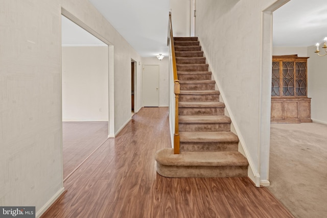 staircase featuring baseboards and wood finished floors