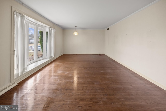 unfurnished room featuring ornamental molding, a baseboard heating unit, baseboards, and wood finished floors