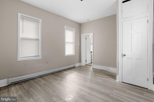 unfurnished room with light wood-type flooring, baseboards, and baseboard heating