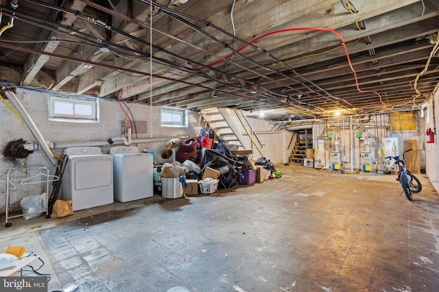 below grade area featuring water heater, washing machine and dryer, and stairs