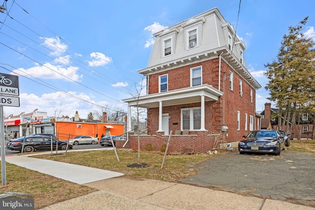 victorian home with a front lawn and brick siding