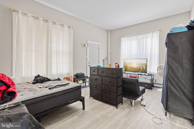 bedroom featuring light wood-style flooring and a baseboard radiator