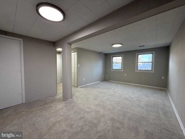 basement with carpet, visible vents, and baseboards