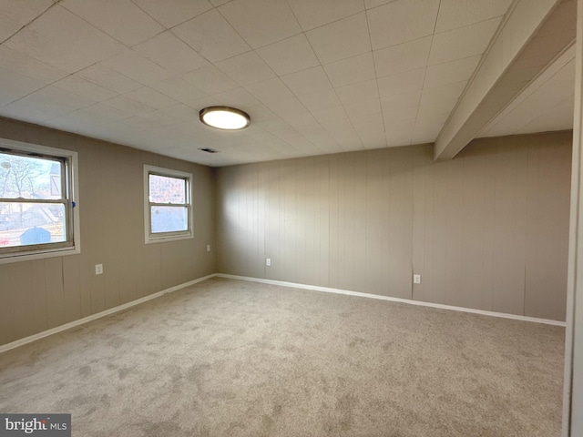 spare room featuring carpet, visible vents, and baseboards