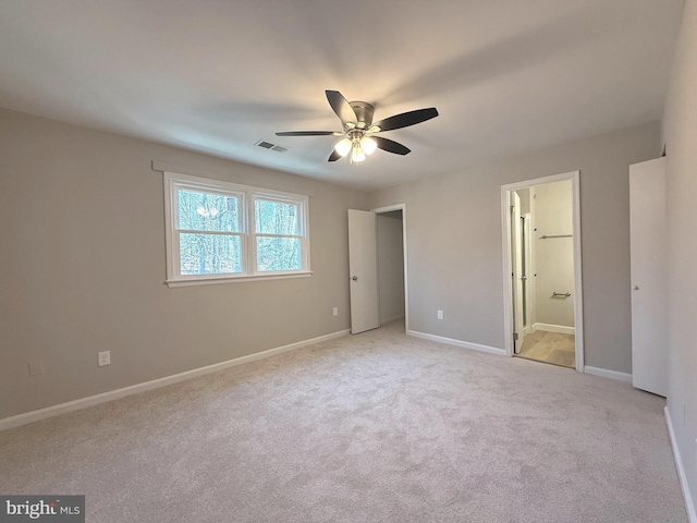 unfurnished bedroom with ceiling fan, connected bathroom, light carpet, visible vents, and baseboards