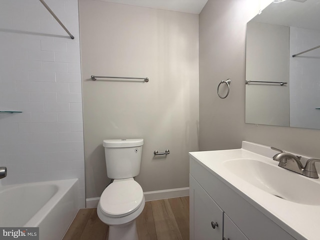 full bathroom with baseboards, toilet, wood finished floors, bathtub / shower combination, and vanity