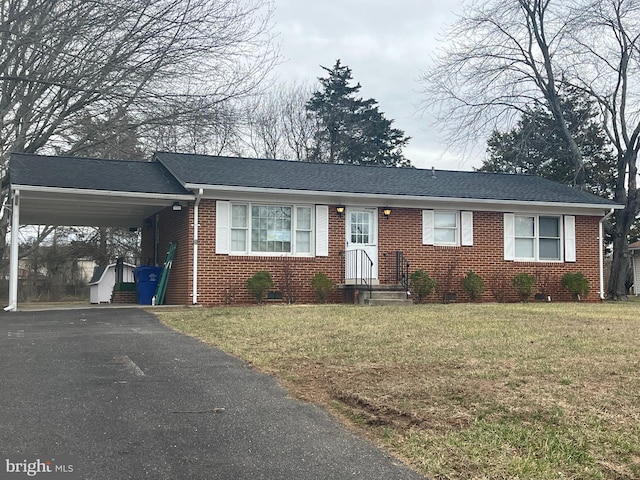 ranch-style home with aphalt driveway, brick siding, roof with shingles, a carport, and a front lawn