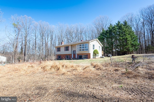 raised ranch with a chimney and brick siding