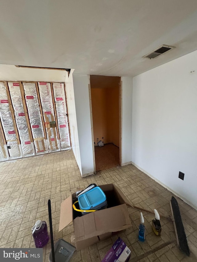 spare room featuring brick floor and visible vents