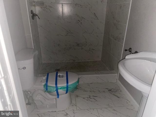 full bathroom with marble finish floor and a stall shower