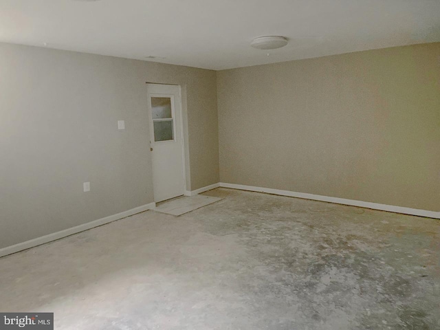 unfurnished room featuring baseboards and concrete floors