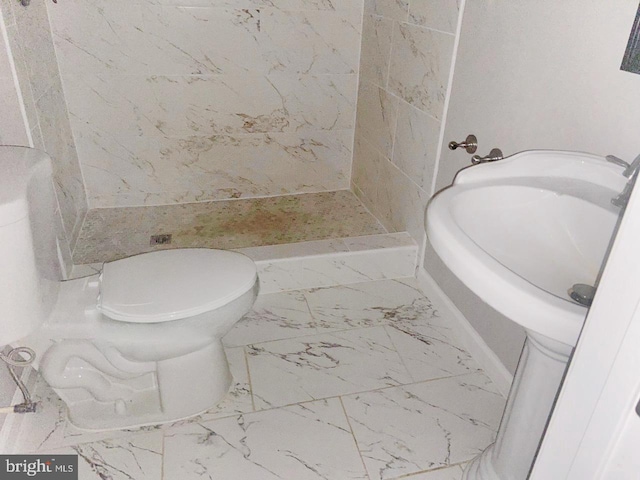 full bathroom featuring marble finish floor, a stall shower, and toilet