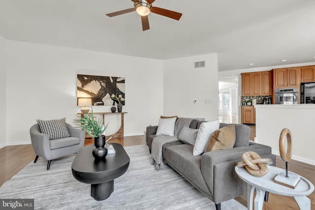 living area with a ceiling fan, wood finished floors, visible vents, baseboards, and recessed lighting