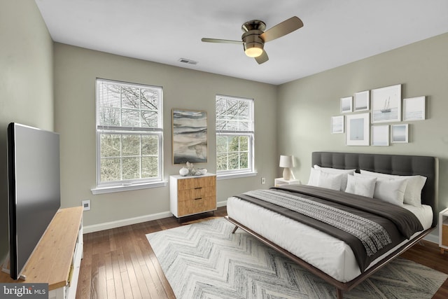 bedroom with visible vents, baseboards, a ceiling fan, and dark wood-style flooring