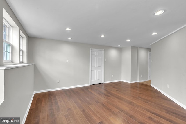 spare room with recessed lighting, dark wood-type flooring, and baseboards