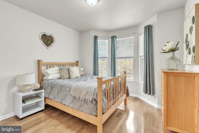 bedroom with light wood finished floors and baseboards