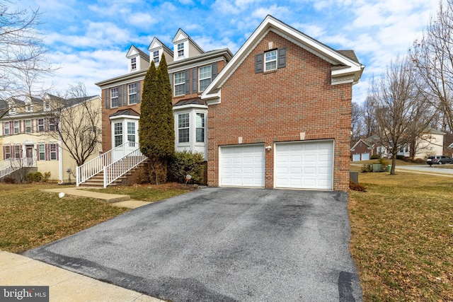 view of front of home with aphalt driveway, a garage, brick siding, and a front yard