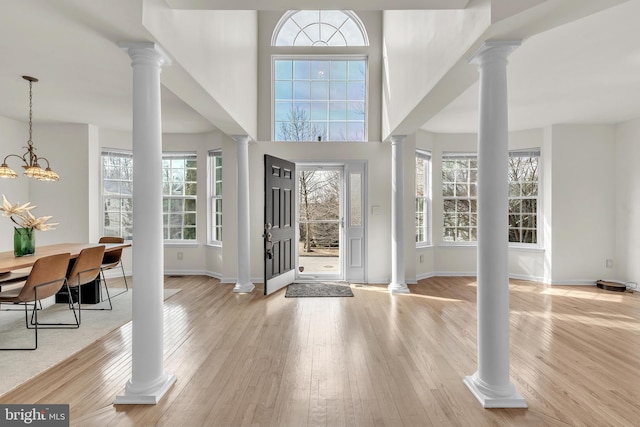 foyer entrance with hardwood / wood-style flooring, decorative columns, and plenty of natural light