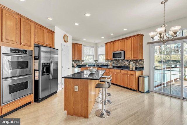 kitchen featuring dark countertops, a kitchen breakfast bar, a center island, and stainless steel appliances