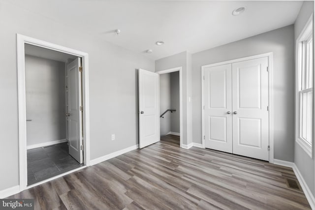 unfurnished bedroom with baseboards, visible vents, and wood finished floors