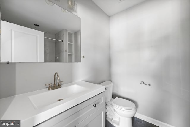 full bathroom with a shower, vanity, toilet, and baseboards