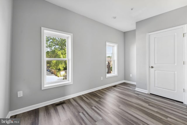 unfurnished bedroom with baseboards, visible vents, and wood finished floors