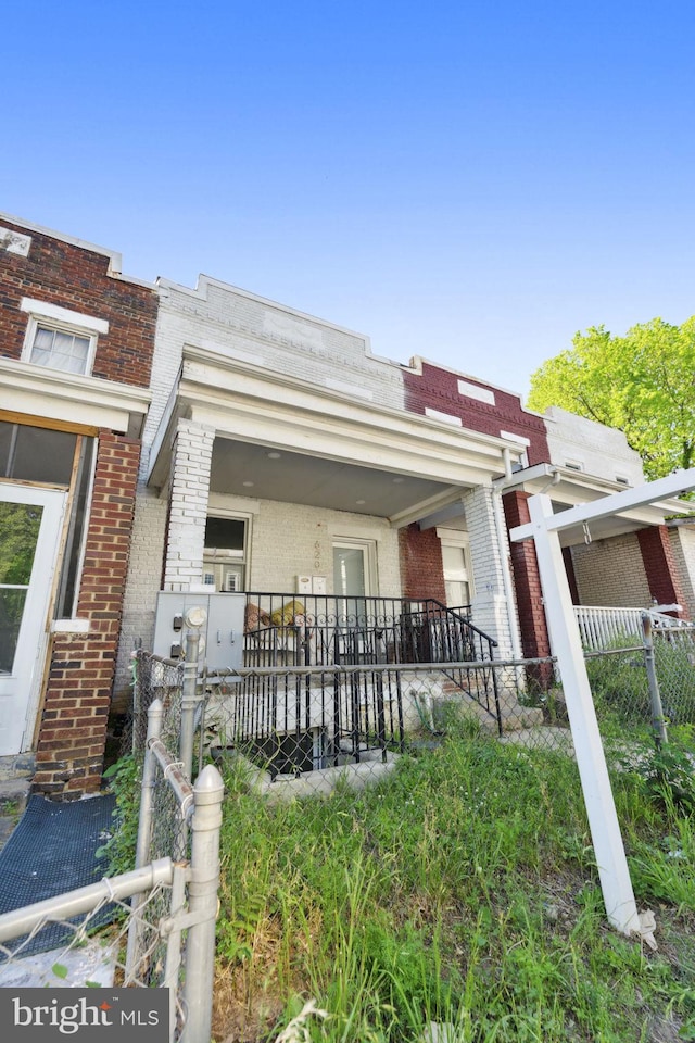 view of property featuring fence and brick siding