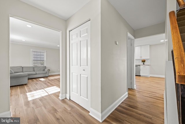 hallway with recessed lighting, light wood-style flooring, and baseboards