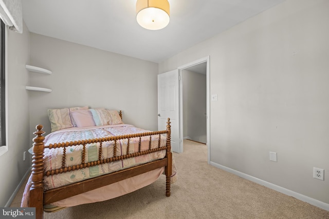 bedroom featuring light colored carpet and baseboards