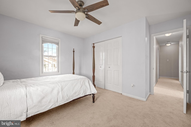 carpeted bedroom with a closet, ceiling fan, and baseboards