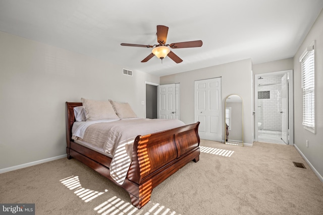 bedroom featuring visible vents, ensuite bathroom, baseboards, and carpet floors