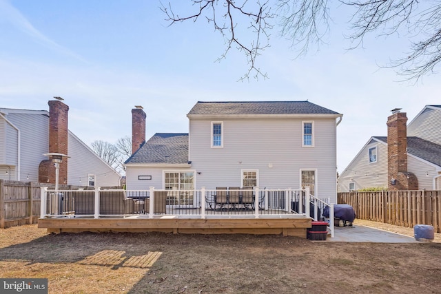 back of house with a patio area, a deck, a chimney, and a fenced backyard