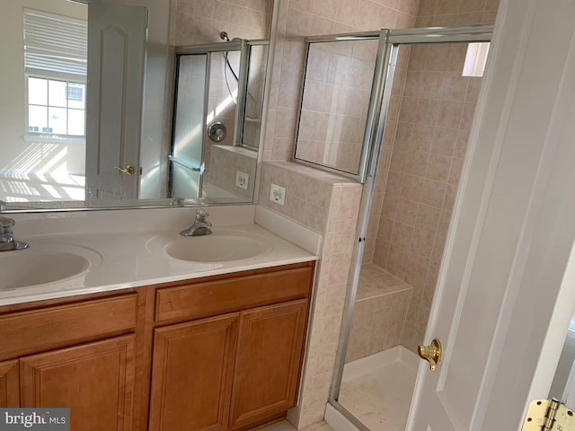 full bathroom with a stall shower, a sink, and double vanity