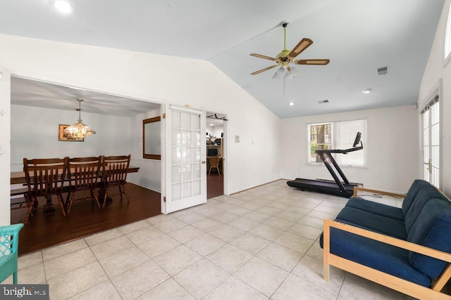 living area featuring vaulted ceiling, light tile patterned floors, ceiling fan with notable chandelier, and visible vents