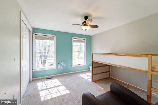 unfurnished room featuring carpet floors, baseboards, visible vents, and ceiling fan