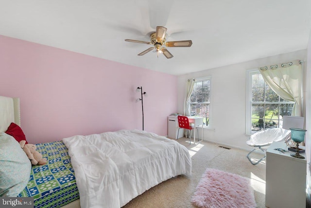 carpeted bedroom with ceiling fan and visible vents